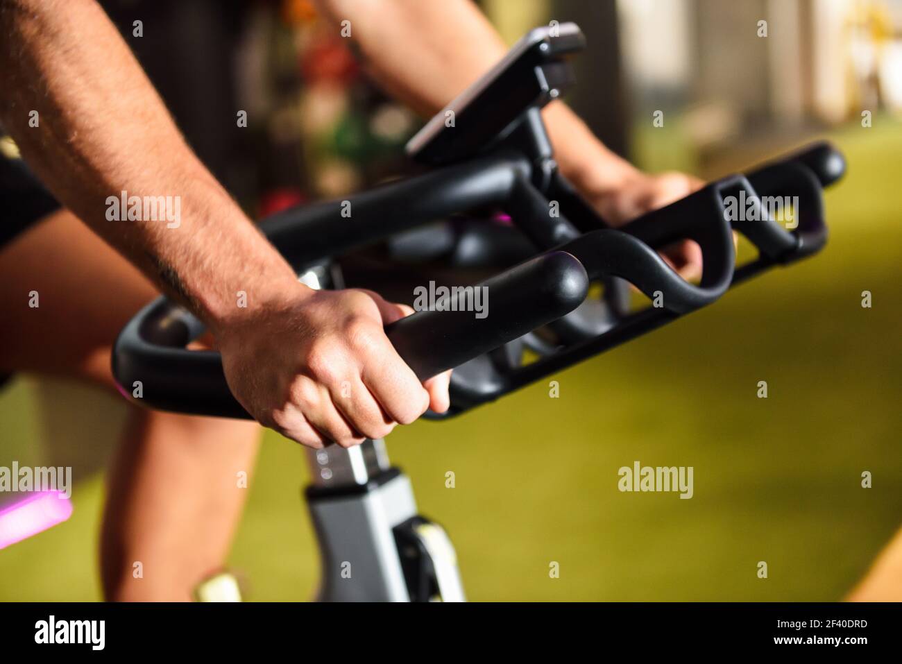 Le mani di un uomo di formazione presso una palestra facendo il cyclo indoor. Sport e fitness concetto. Foto Stock