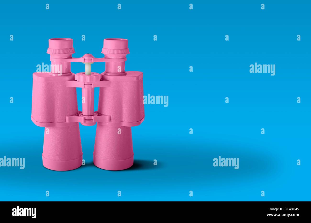 Binocolo rosa isolato su sfondo blu Foto Stock