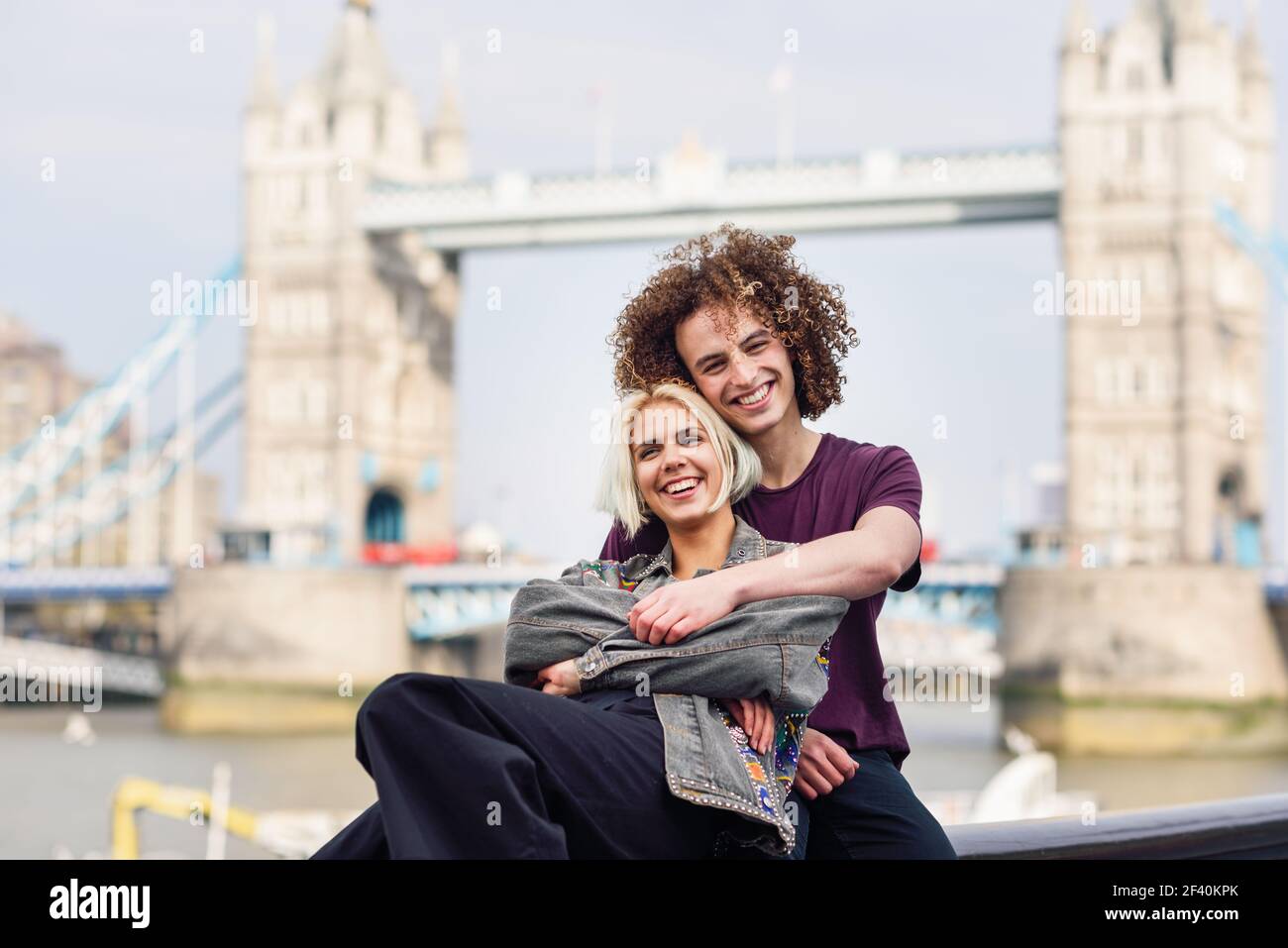 Felice coppia abbracciando al Tower Bridge, River Thames, Londra. REGNO UNITO. Felice coppia abbracciando al Tower Bridge Foto Stock