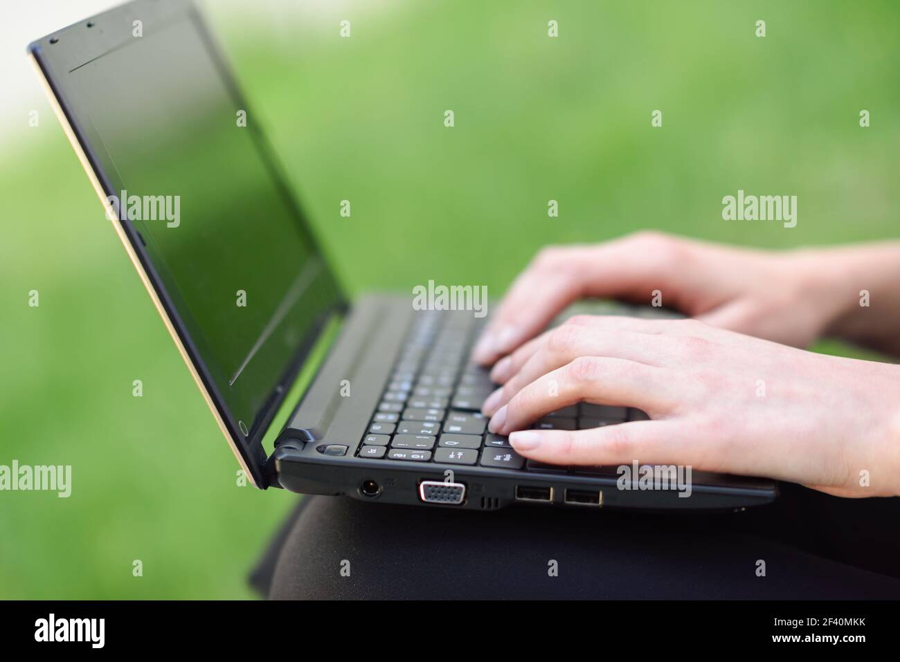 Donna mani che digitano sulla tastiera del computer portatile all'aperto. Le mani della donna che scrivano sulla tastiera del computer portatile. Foto Stock