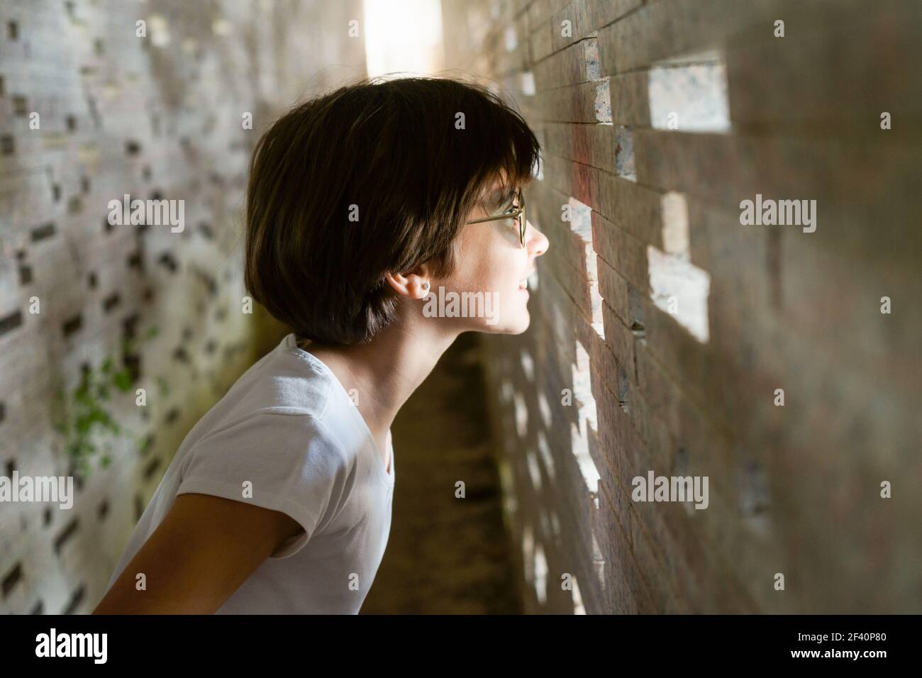 Bambino che guarda attraverso i mattoni all'interno del restauro del Muro Nazariano dell'Albaicin a Granada, realizzato dall'architetto Antonio Jimenez Torrecillas. Bambino che guarda attraverso i mattoni all'interno del muro di Nazari Foto Stock Bambino che guarda attraverso i mattoni all'interno del restauro del Muro Nazariano dell'Albaicin a Granada, realizzato dall'architetto Antonio Jimenez Torrecillas. Bambino che guarda attraverso i mattoni all'interno del muro di Nazari Foto Stock