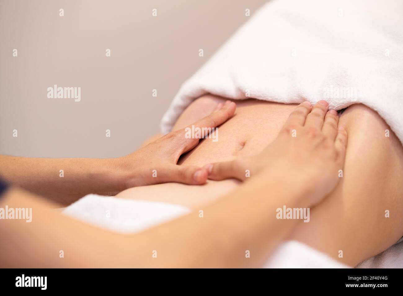 Donna che riceve un massaggio del ventre presso il centro benessere. La paziente femminile sta ricevendo il trattamento da un terapeuta professionale di osteopatia. Donna che riceve un massaggio del ventre presso il centro benessere Foto Stock