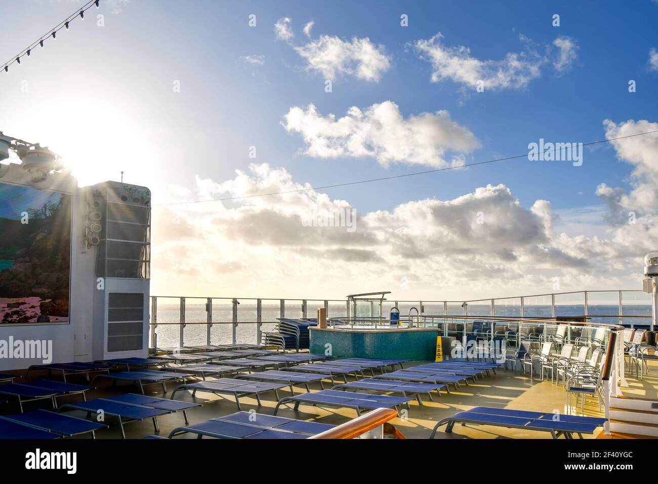 Area lounge sul ponte superiore con sedie, salotti e una vasca per capanne su una nave da crociera in mare. Foto Stock