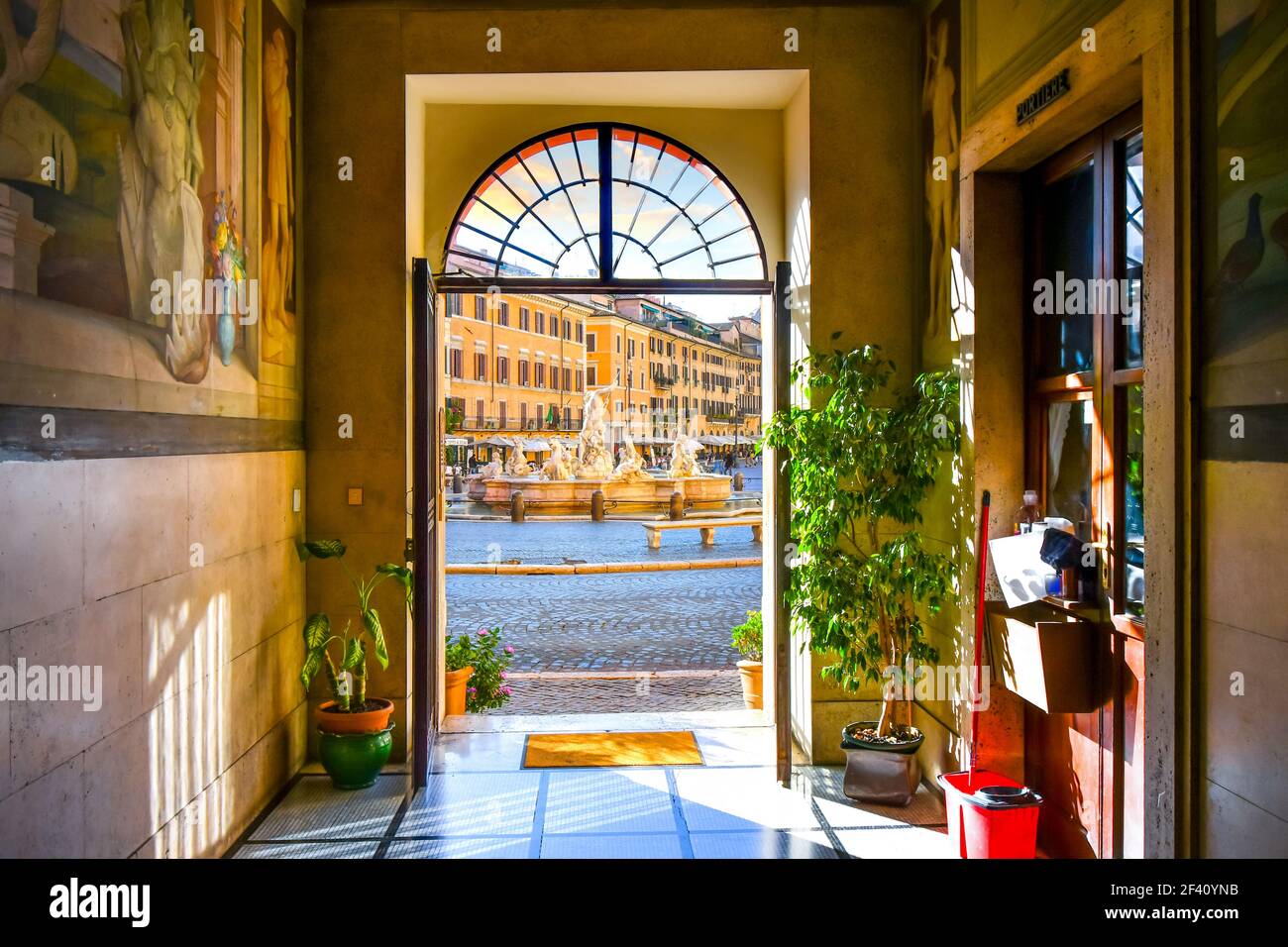 Vista della Fontana del Nettuno con caffè all'interno di una porta di un edificio medievale sulla Piazza Navona di Roma, Italia Foto Stock