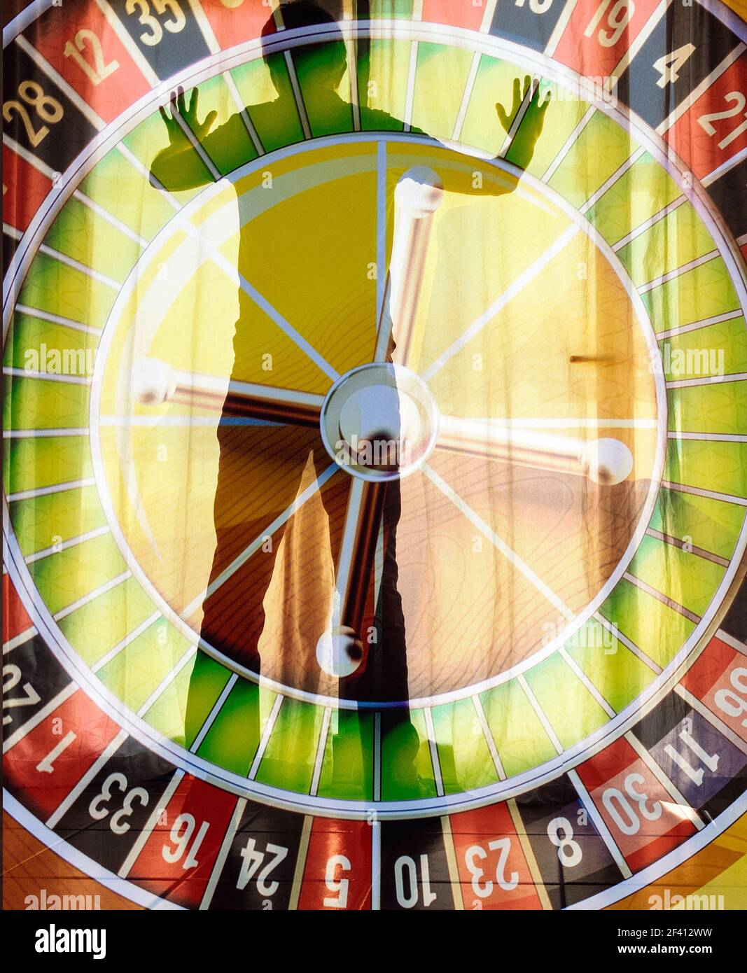 Vista posteriore di un uomo maturo che guarda fuori dalla finestra con la ruota della roulette sovrapposta. Gioco d'azzardo, dipendenza dal gioco d'azzardo, salute mentale, debito... concetto Foto Stock