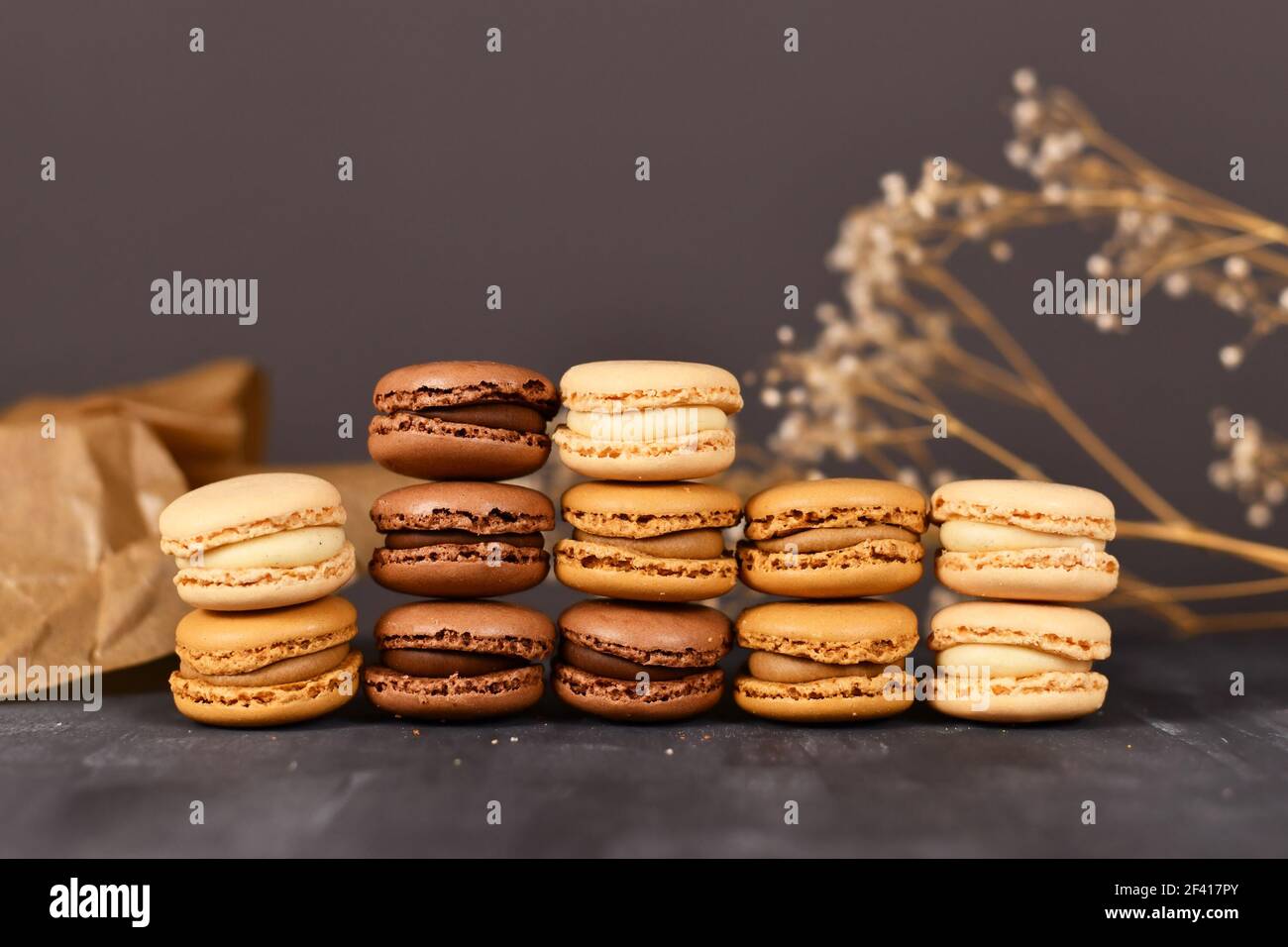 Pile di macaron francesi naturali di colore marrone, beige e crema con aroma di caffè, moka, cioccolato e vaniglia Foto Stock