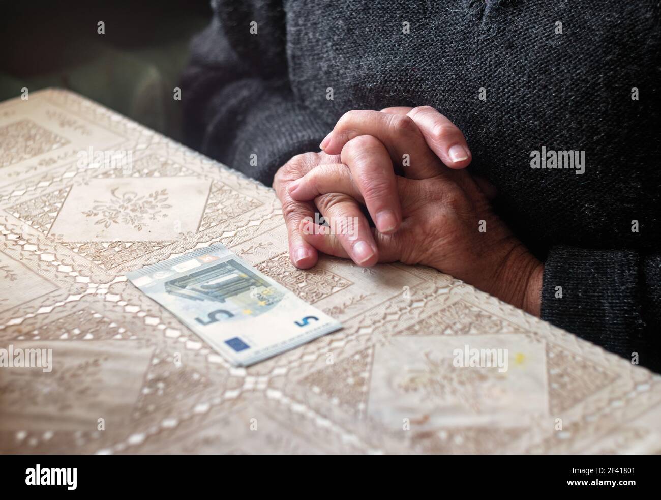 Donna anziana che piangono come spendere la sua pensione. Donna con circa cinque banconote in euro sul tavolo davanti al suo colpo con copyspace Foto Stock