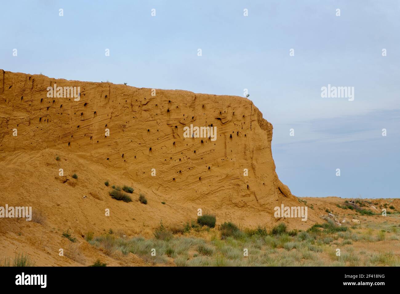 Deserto arance Clay Cliff con buchi di nido di rondine, un sacco di copyspace su un cielo.. Deserto arance Clay Cliff con buchi di nido di rondine, un sacco di c Foto Stock