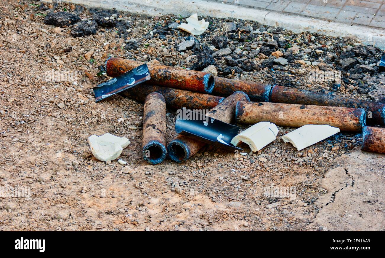 Mazzo di tubi arrugginiti corrosi che giacciono a terra nel cortile. Mazzo di tubi arrugginiti che giacciono a terra Foto Stock