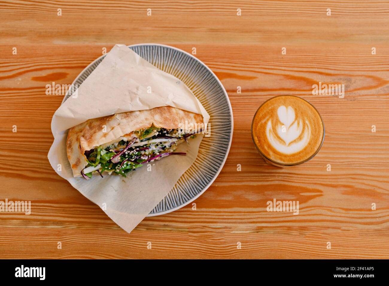 Shawerma sandwich pollo roll in pita su piatto con verdure fresche e piatto-bianco su tavolo di legno vista. Involtino di pollo Shaverma in pita con verdure fresche e vista dall'alto in bianco piatto su un tavolo di legno Foto Stock