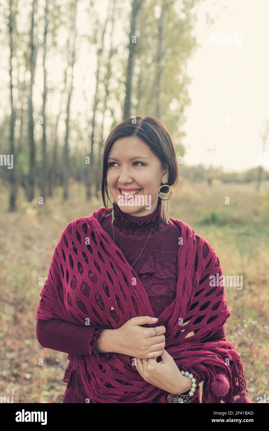 Felice studente che posa fuori in cardigan viola Foto Stock