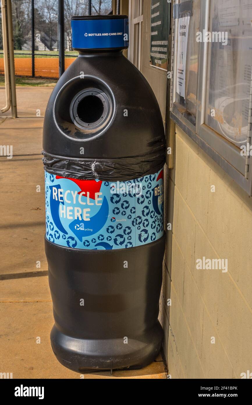 Un contenitore in plastica a forma di bottiglia grande utilizzato per il riciclaggio delle bottiglie e lattine solo in un campo di baseball accanto a. stand di concessione in un parco Foto Stock