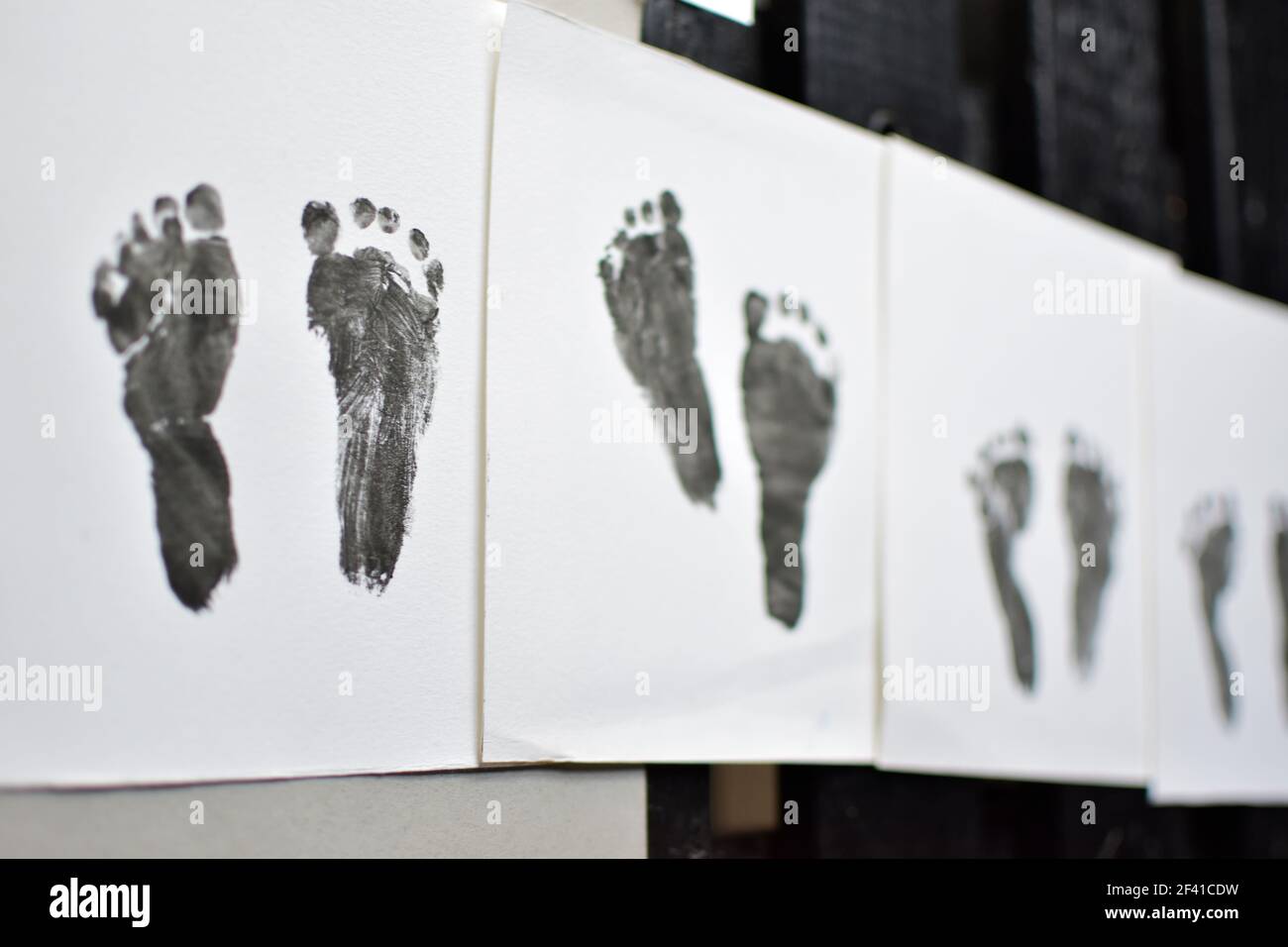 Il piede del bambino stampa in fila. Quattro coppie di impronte dei piedi del bambino Foto Stock