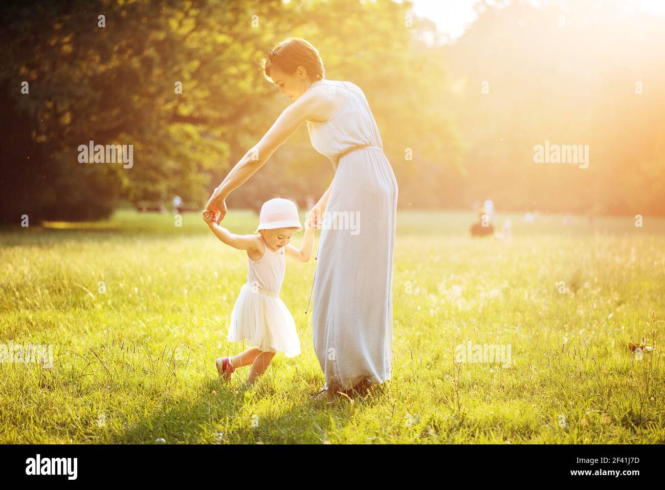 Attraente madre ballare con sua figlia sul prato Foto Stock