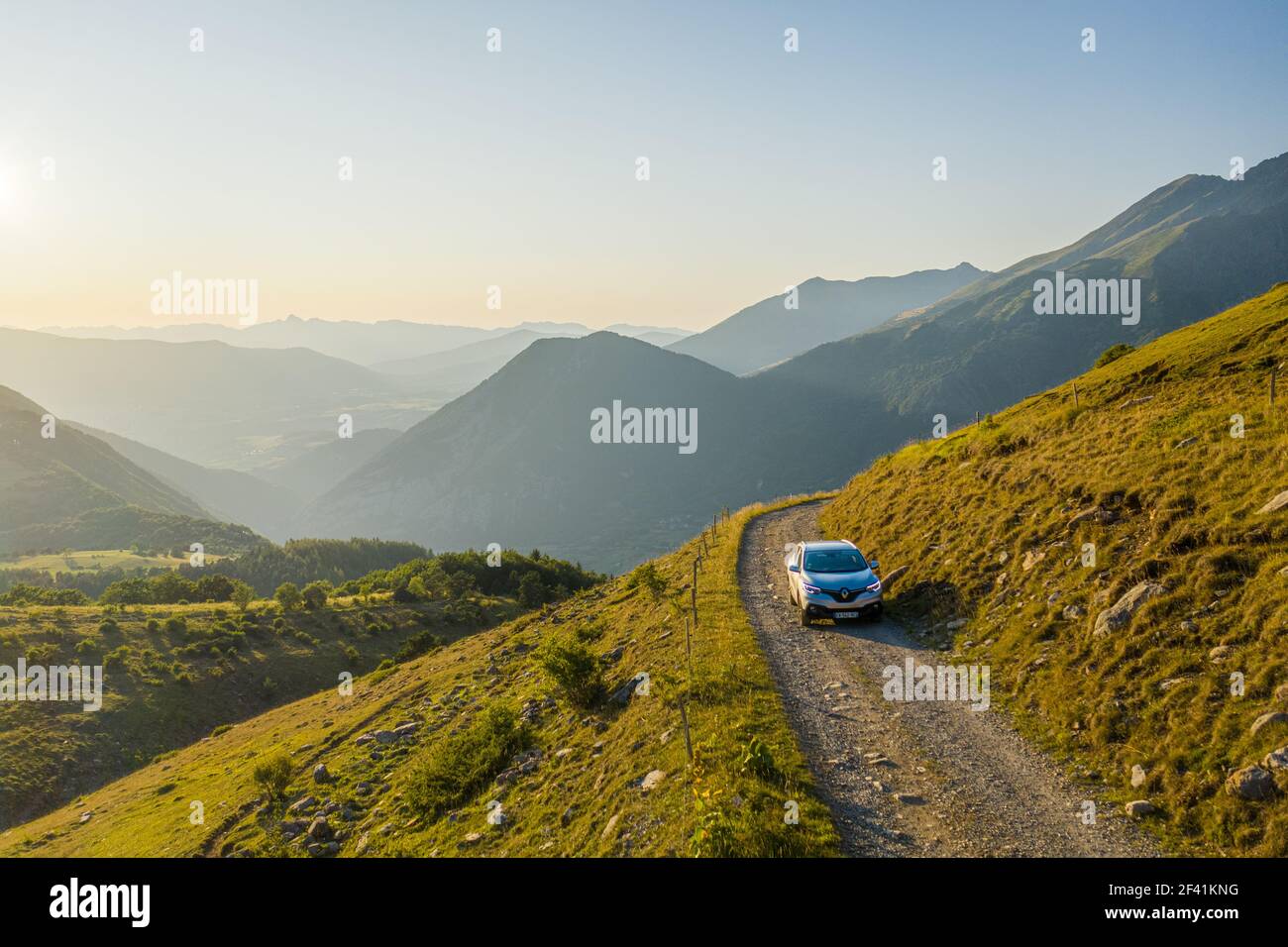 Vista dall'antenna anteriore di un'auto a quattro ruote che guida fino a. strada di montagna in bellissimo paesaggio collinare Foto Stock