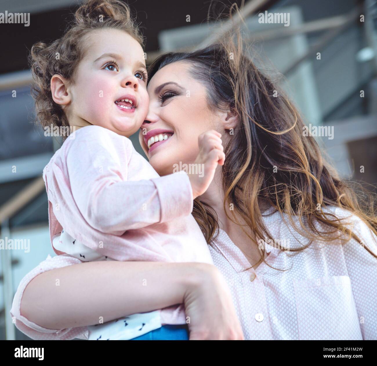 Ritratto di un allegro mom cuddling cara figlia Foto Stock