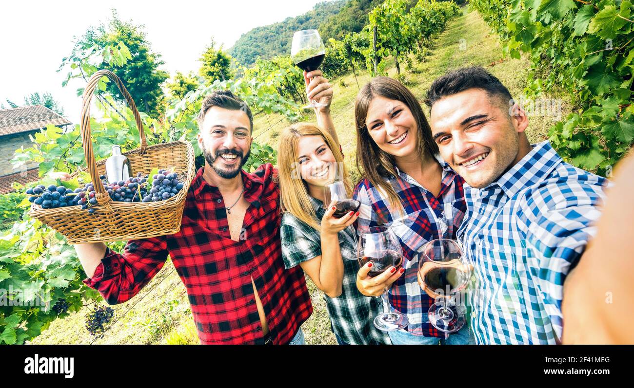 Giovani amici che si divertono a prendere selfie in cantina vigneto all'aperto - concetto di amicizia sulle persone felici che godono insieme raccolto a. casa colonica Foto Stock