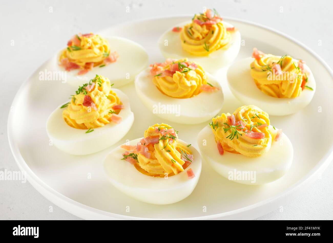 Uova farcite con tuorlo d'uovo, pancetta, senape e aneto, vista ravvicinata Foto Stock