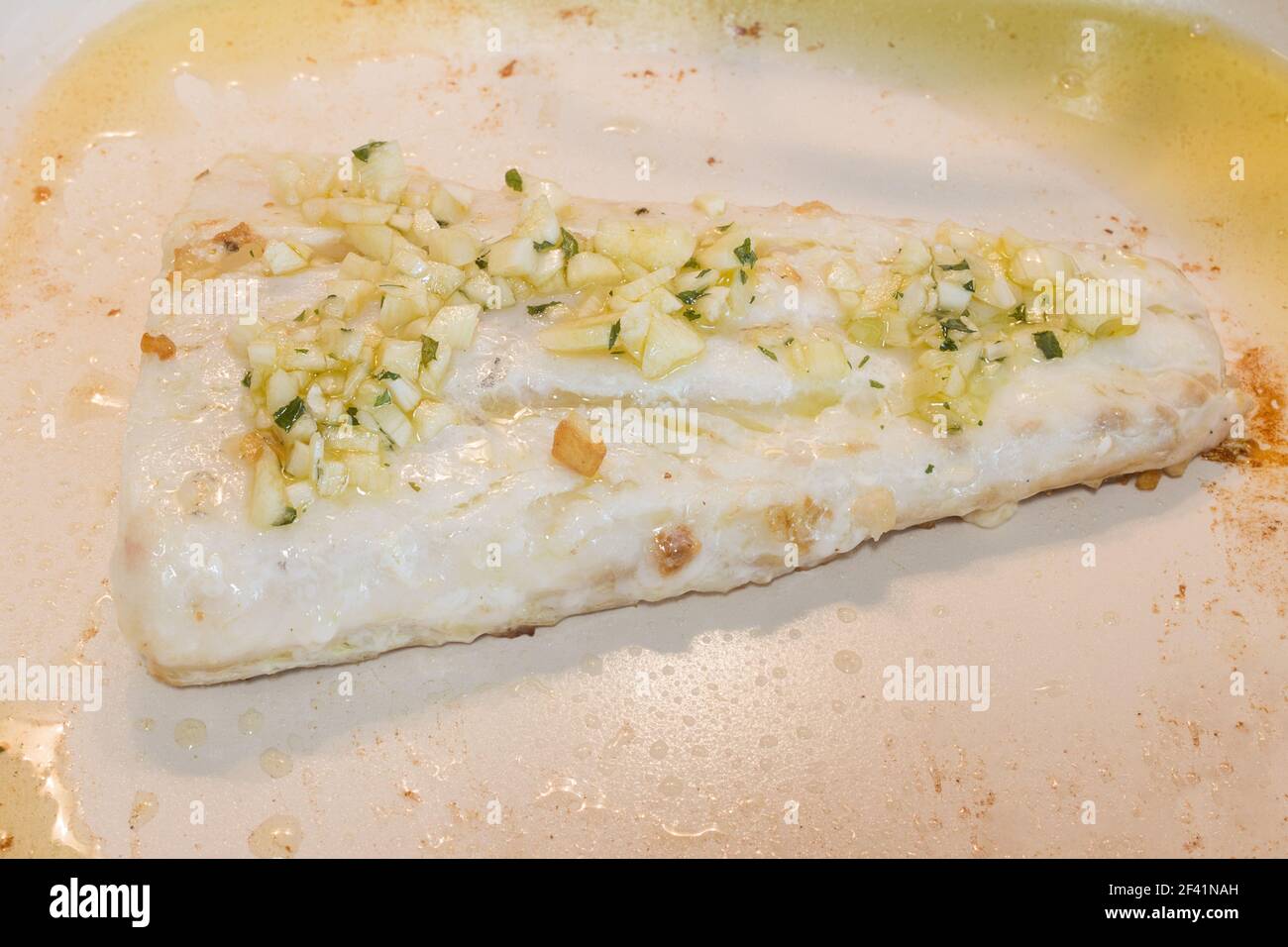 Sfornare il filetto con aglio, prezzemolo e olio d'oliva in una padella di ceramica. Cibo sano. Foto Stock