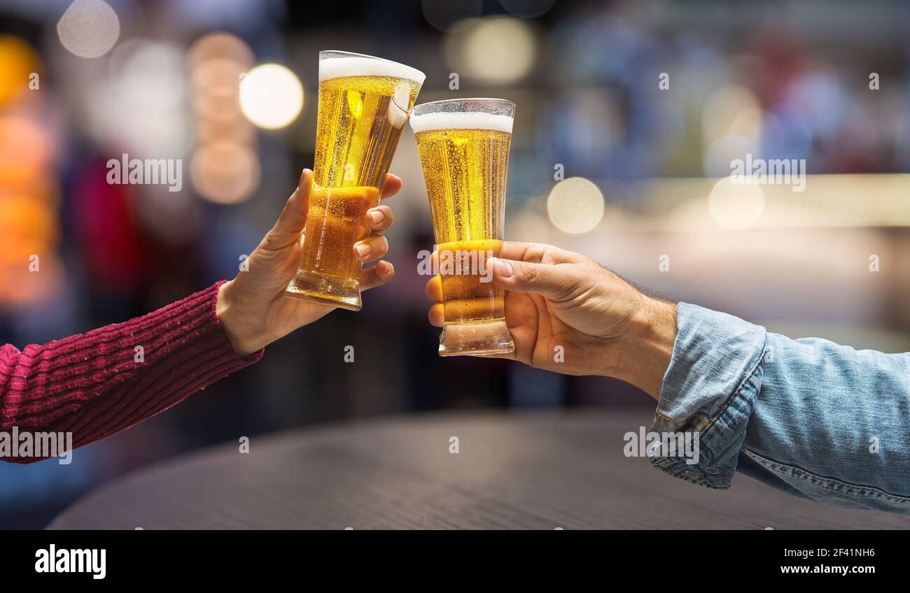 Tostatura con bicchieri di birra leggera. Interno pud sfocato sullo sfondo. Foto Stock