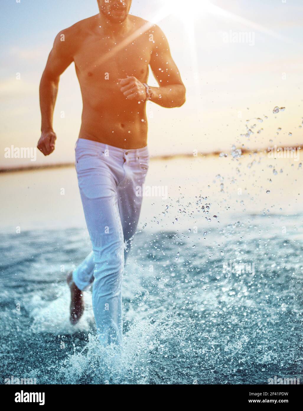 Estate colpo di un ragazzo che corre lungo il mare Foto Stock