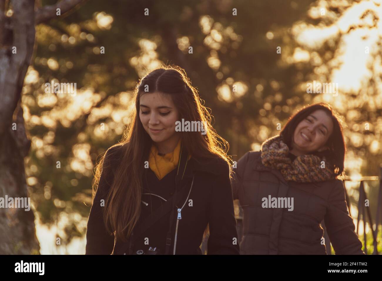 Madre matura e giovane figlia camminando lungo il Paseo de las Murallas de Baeza (Spagna) nell'ora d'oro Foto Stock