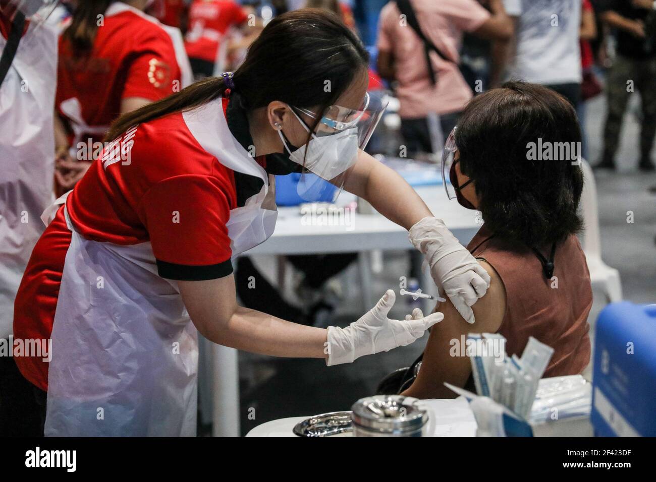 Un operatore sanitario inietta una dose del vaccino Sinovac durante un viaggio di vaccinazione a San Juan City, Metro Manila, Filippine. Foto Stock