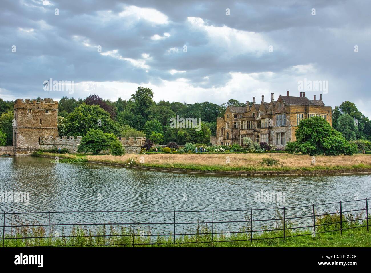 Broughton Castle, vicino Banbury, Oxfordshire, con Moathouse, preso dai campi ai lati opposti del fossato. Cielo artistico. Foto Stock