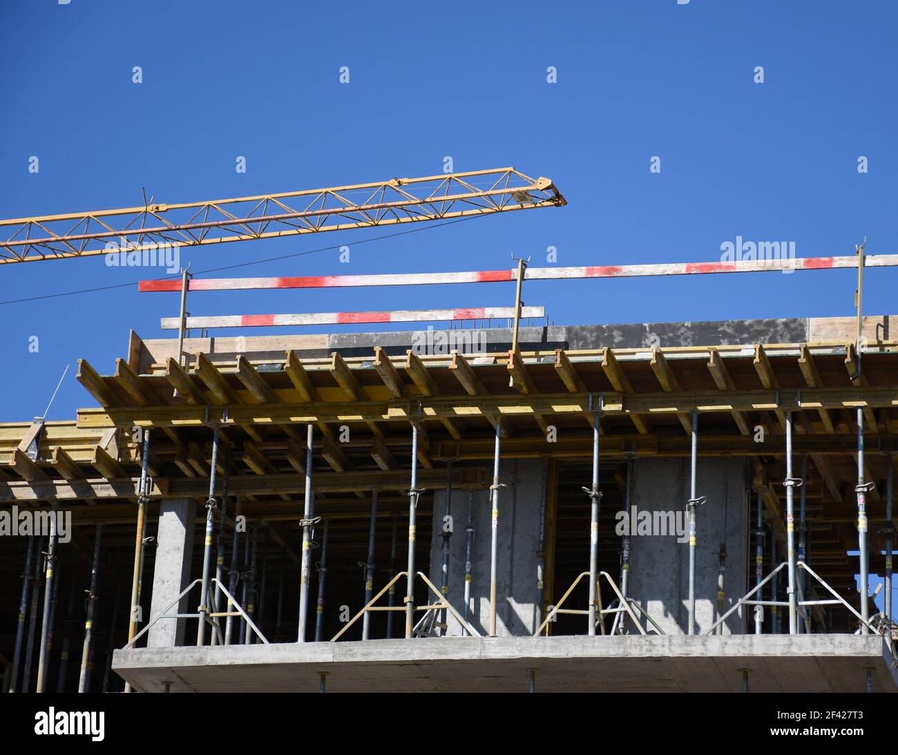 struttura in calcestruzzo. struttura edilizia. costruzione. cassaforma in acciaio e legno e impalcature. rivestimento in compensato. barriera di sicurezza in legno a strisce rosse Foto Stock
