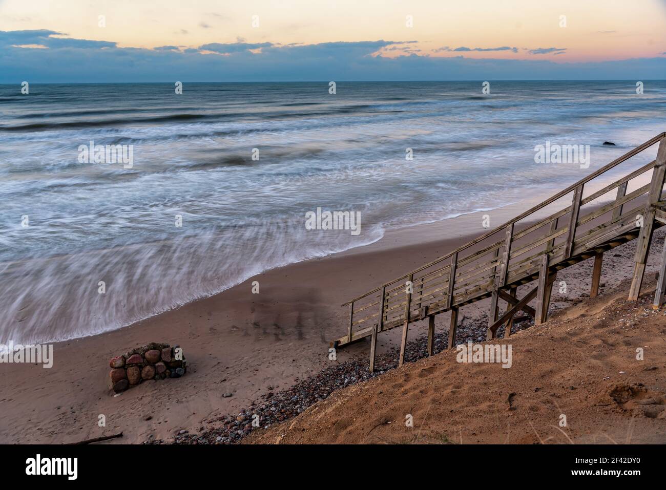 una scalinata in legno che permette di raggiungere la spiaggia molto vicina al litorale dell'acqua, proprio come entrare direttamente nell'acqua di mare Foto Stock