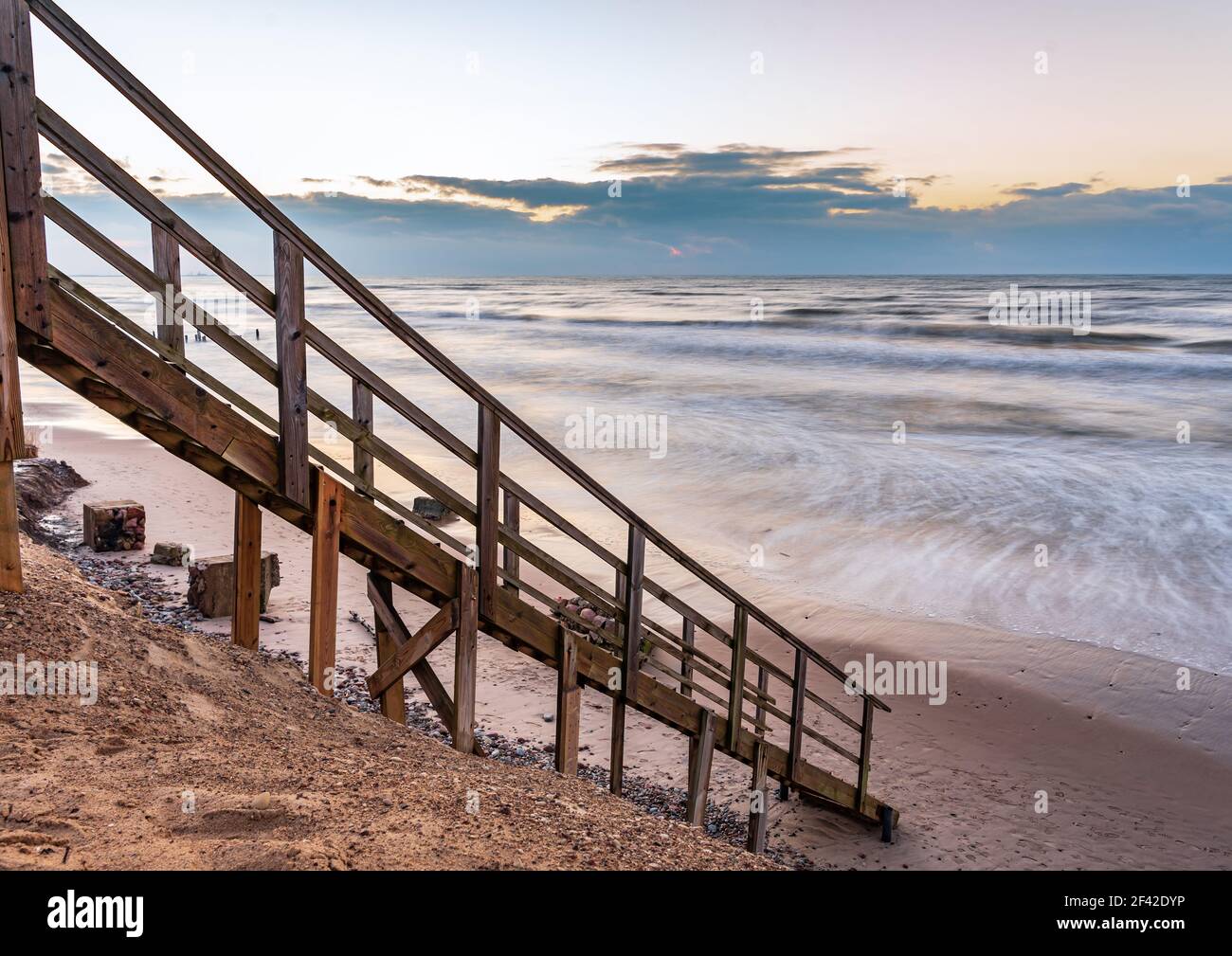 una scalinata in legno che permette di raggiungere la spiaggia molto vicina al litorale dell'acqua, proprio come entrare direttamente nell'acqua di mare Foto Stock