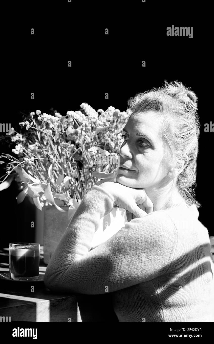 Donna bionda che ha un caffè in una caffetteria II Foto Stock
