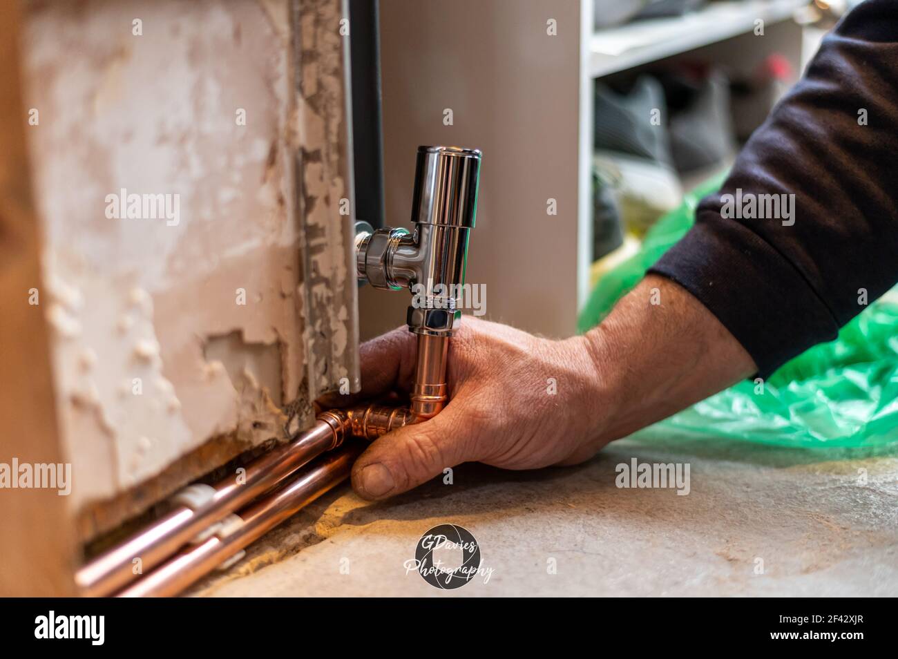 Primo piano di mani maschili che tubano il nuovo radiatore a casa pronto per essere saldato. Concetto diy Foto Stock