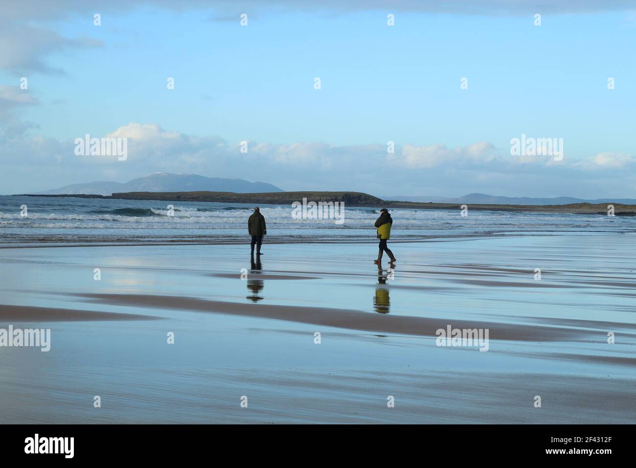 Due uomini sulla riva del mare che si affacciano sull'Oceano Atlantico, Irlanda Foto Stock