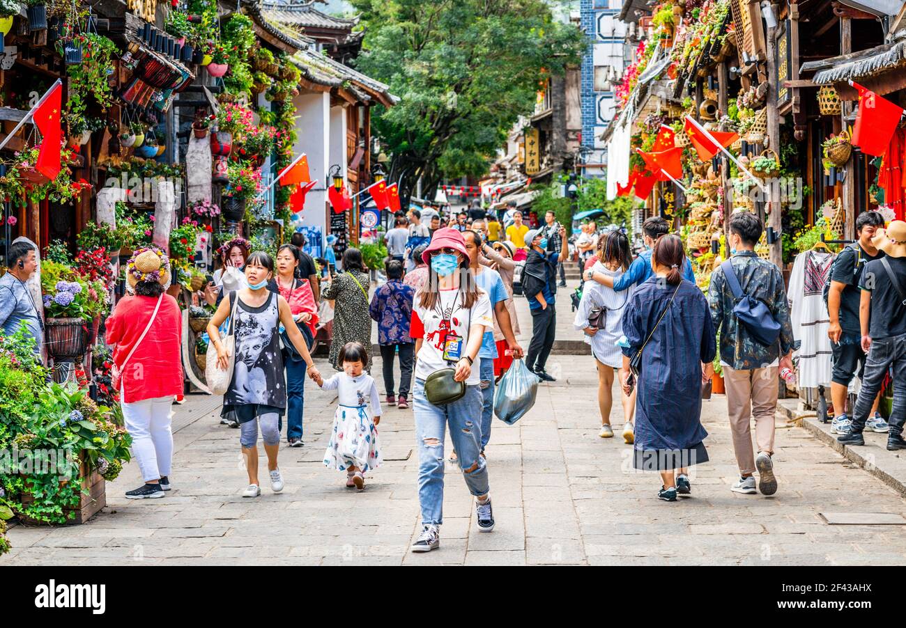 Dali Cina , 5 ottobre 2020 : donna cinese che indossa maschera chirurgica blu durante 2020 vacanze settimana d'oro nel mezzo di altre persone in Dali vecchia stoppa Foto Stock
