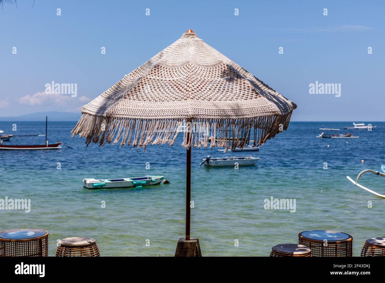 Ombrellone coccinato sulla spiaggia di Sanur. Oceano, barche, cielo blu. Bali, Indonesia. Foto Stock