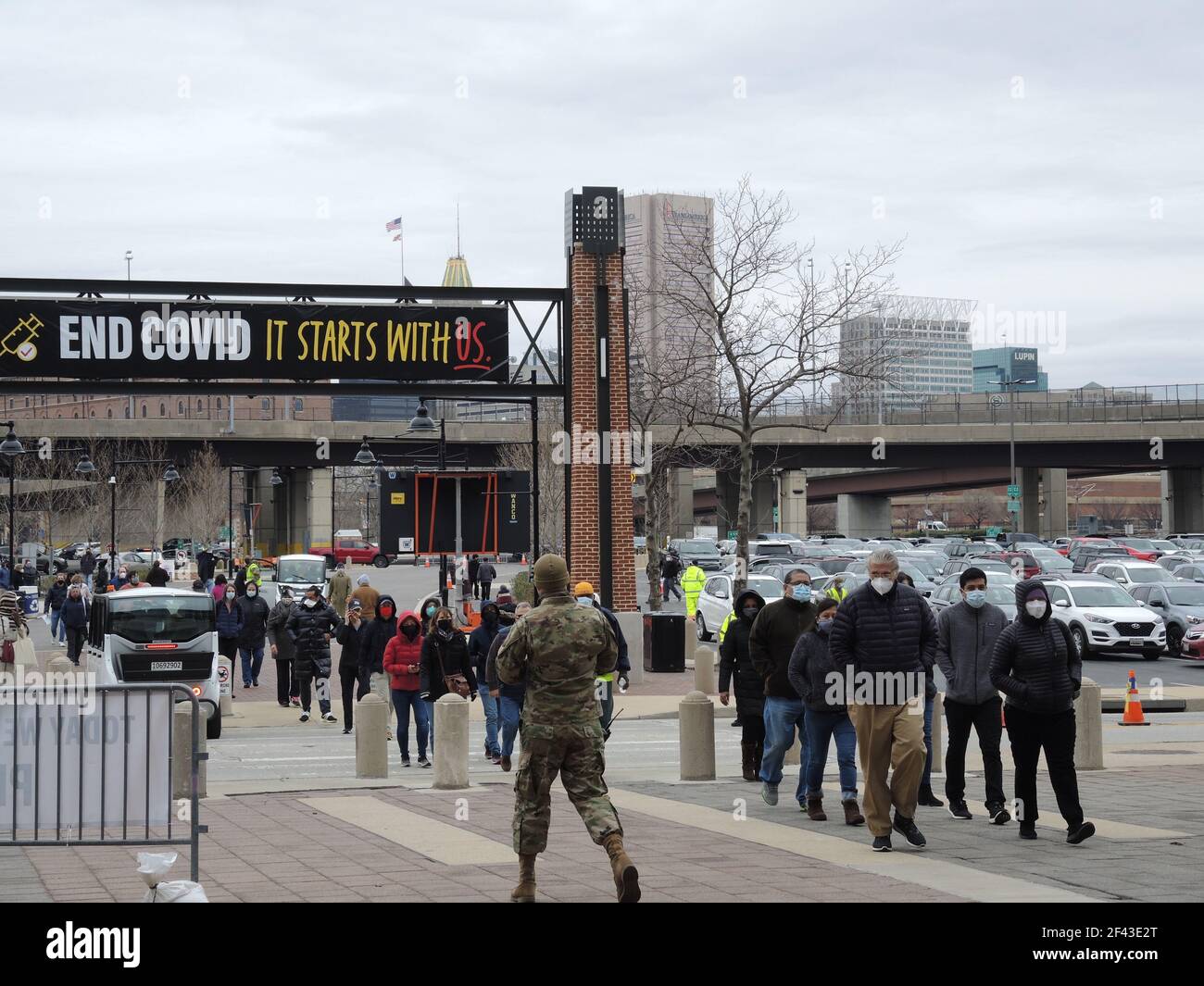 Baltimora, Stati Uniti. 16 Marzo 2021. Un gruppo di persone cammina verso l'ingresso dello stadio di football Baltimora Ravens nella città americana di Baltimora, che da quasi un mese funge da centro di immunizzazione di massa. La Guardia Nazionale sta assistendo con la logistica. (Al dpa: ''finalmente con il sistema' contro la pandemia: La campagna di vaccinazione degli Stati Uniti') Credit: Lena Klimkeit/dpa/Alamy Live News Foto Stock