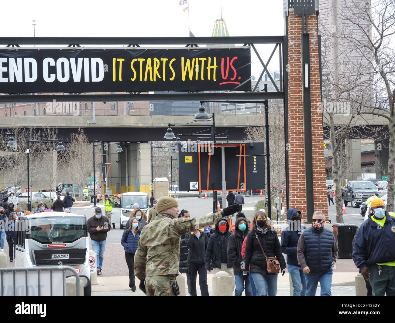 Baltimora, Stati Uniti. 16 Marzo 2021. SGT. Stephen Conkey dirige un gruppo di persone all'ingresso dello stadio di football Baltimora Ravens nella città americana di Baltimora, che da quasi un mese funge da centro di immunizzazione di massa. La Guardia Nazionale sta assistendo con la logistica. Credit: Lena Klimkeit/dpa/Alamy Live News Foto Stock