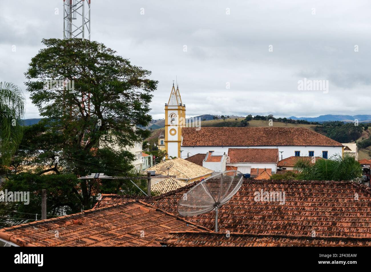Vista parziale dall'alto da una distanza della chiesa di Nossa Senhora da Conceicao tra edifici e sotto il cielo sovrastato. Foto Stock