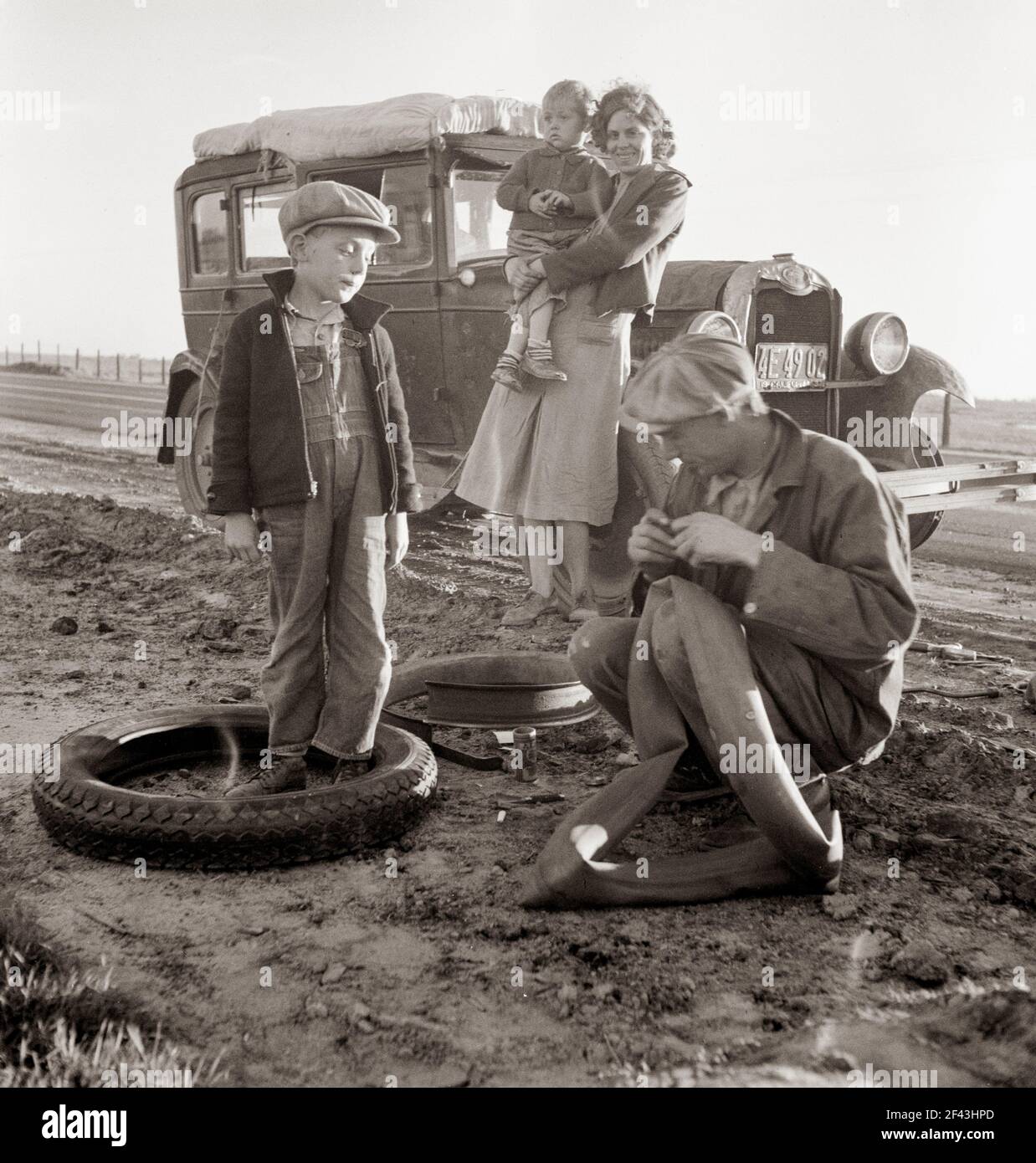 Famiglia di lavoratori agricoli migratori con auto rotta lungo l'autostrada della California. USA 99. Marzo 1937. Fotografia di Dorothea Lange. Foto Stock