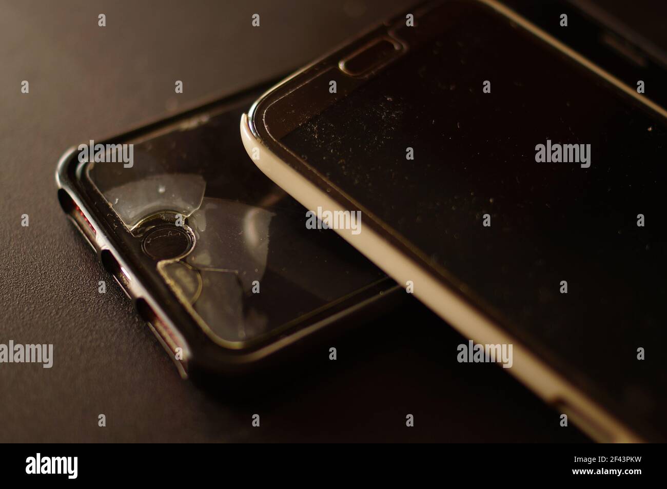 Due telefoni cellulari neri di grandi dimensioni utilizzati. lcd protettivo, con segni di utilizzo. Distruzione e usura sullo schermo. Telefoni che necessitano di assistenza. Foto Stock