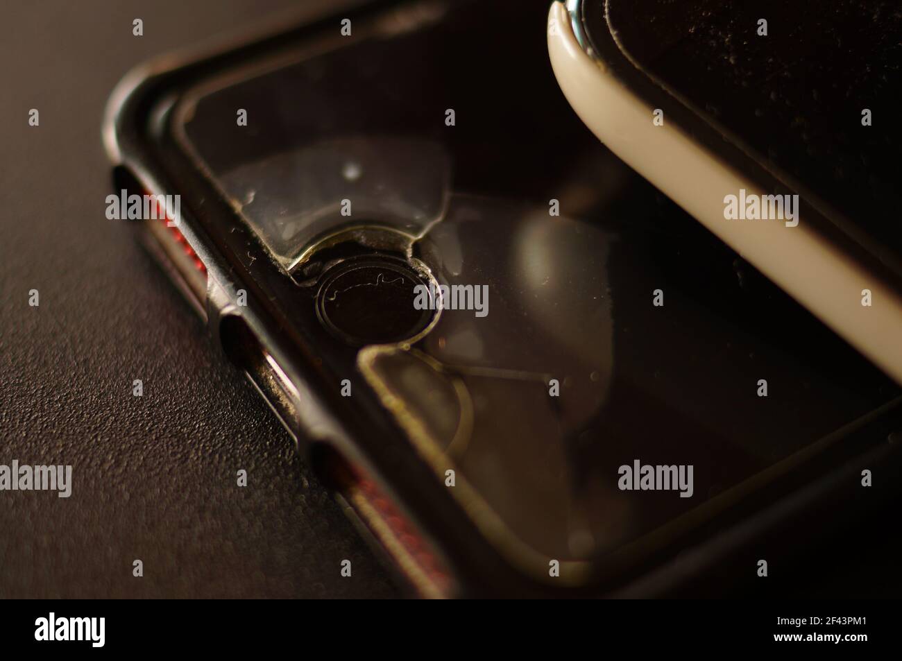 Vetro protettivo dello smartphone - danneggiato, incrinato, usurato. Vecchia protezione dello schermo. Telefono sporco, nero, logoro. Foto Stock