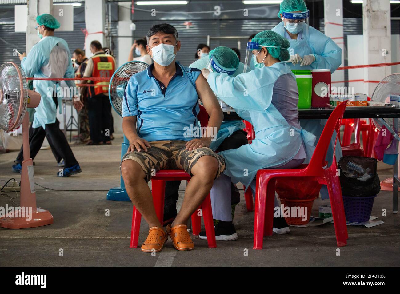 Bangkok, Thailandia. 18 Marzo 2021. Un operatore sanitario inocula un uomo con il vaccino CoronaVac (Sinovac) al mercato di Bang Khae durante un programma di vaccinazione di massa a Bangkok, Thailandia, il 18 marzo 2021. La Bangkok Metropolitan Administration (BMA) ha avviato un programma di vaccinazione di massa all'interno del mercato chiuso di Bang Khae dopo che 224 casi di Covid-19 sono stati trovati tra residenti in e intorno al mercato. Un totale di 6000 dosi saranno somministrate per i prossimi giorni ha detto il governatore. (Foto di Guillaume Payen/SOPA Images/Sipa USA) Credit: Sipa USA/Alamy Live News Foto Stock