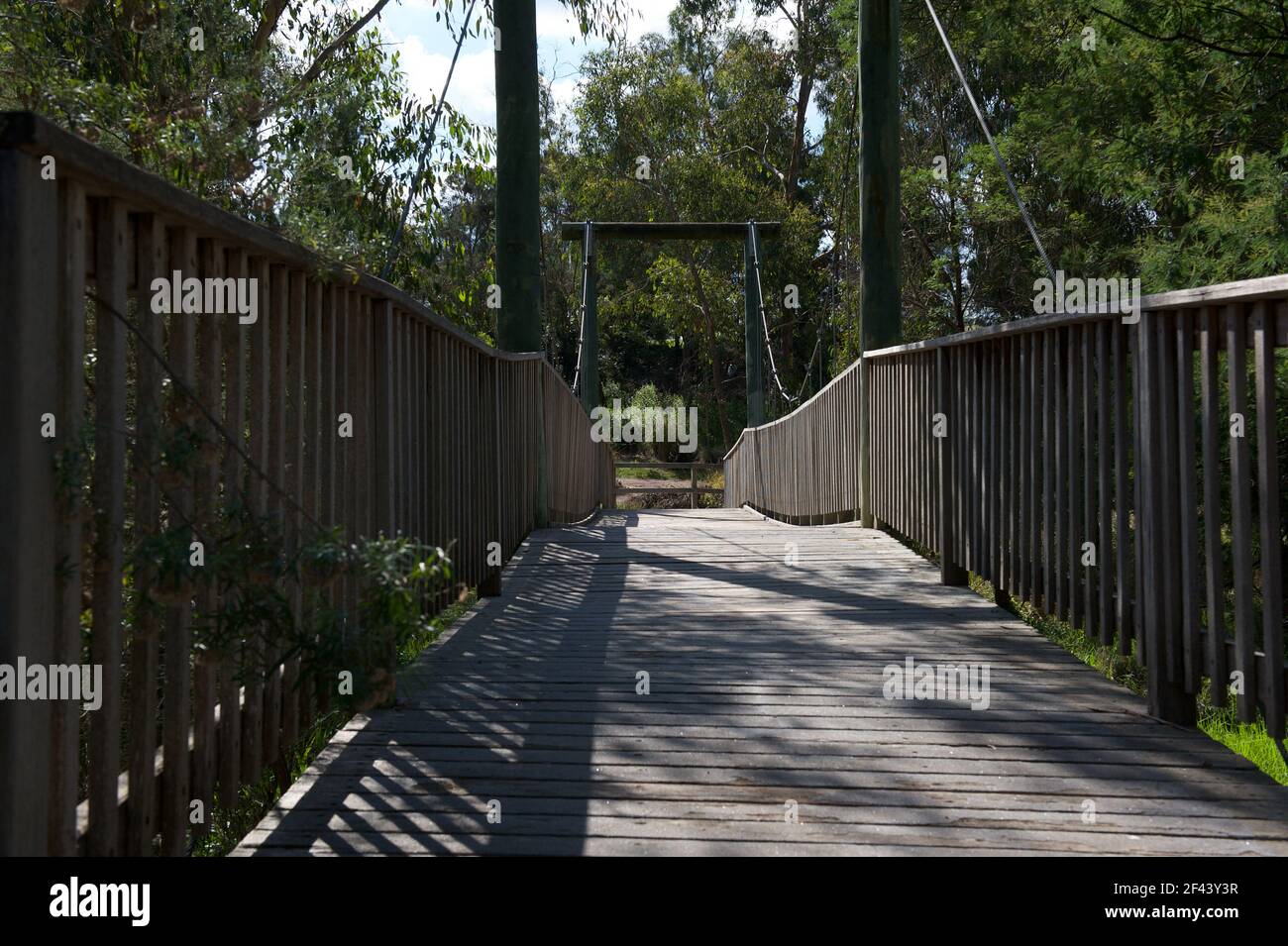 Un primo piano del ponte sospeso in legno di Rupert Street attraverso Mullum Mullum Creek a Ringwood, Victoria, Australia. Foto Stock