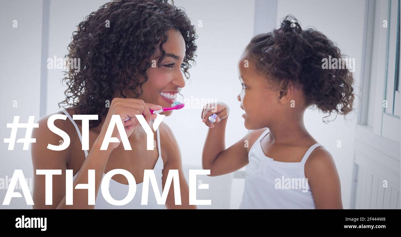 Rimani a casa testo sopra sorridente madre anziana con figlia spazzolando denti Foto Stock