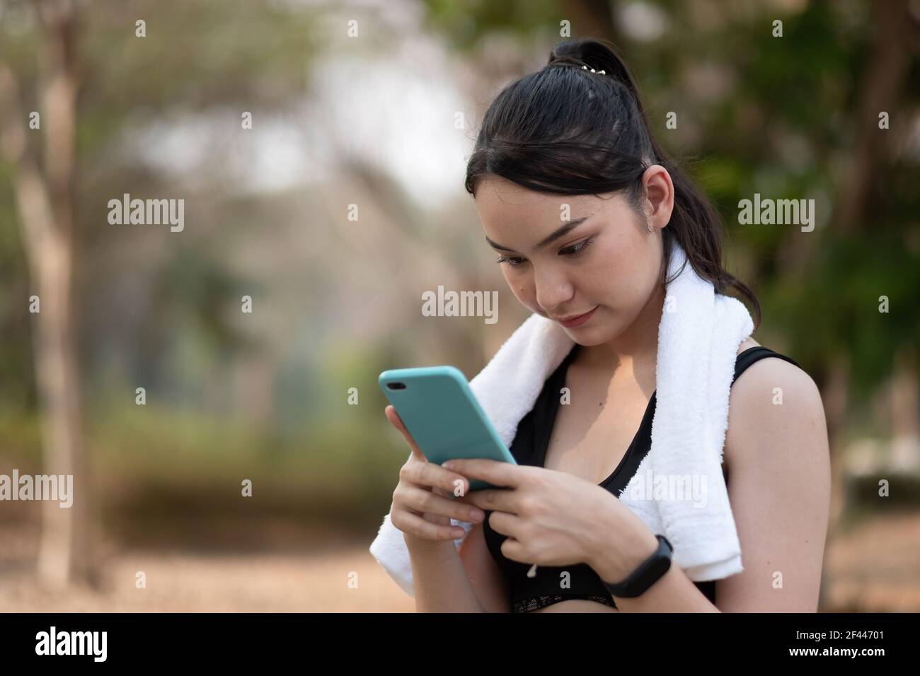 la donna atleta usa uno smartphone in attesa di allenamento Foto Stock