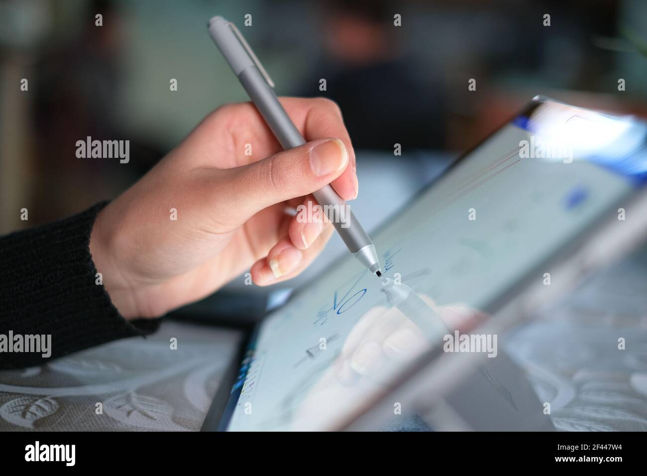 Mano sinistra della donna mentre si usa lo stilo grafico per la casa lavoro intelligente, tecnologia digitale Foto Stock