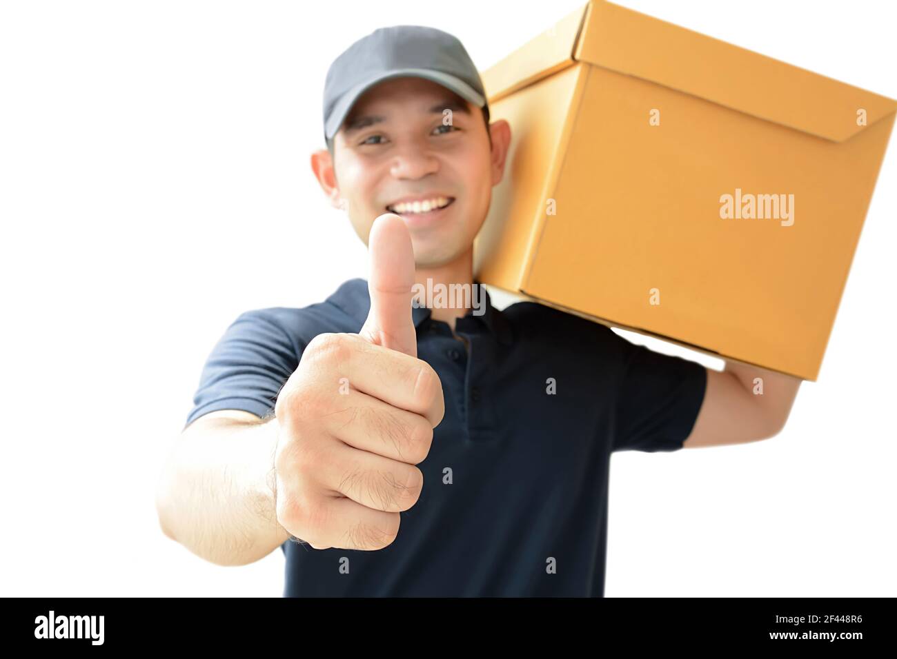 Il deliveryman che trasporta una scatola di pacco che dà i pollici in su Foto Stock