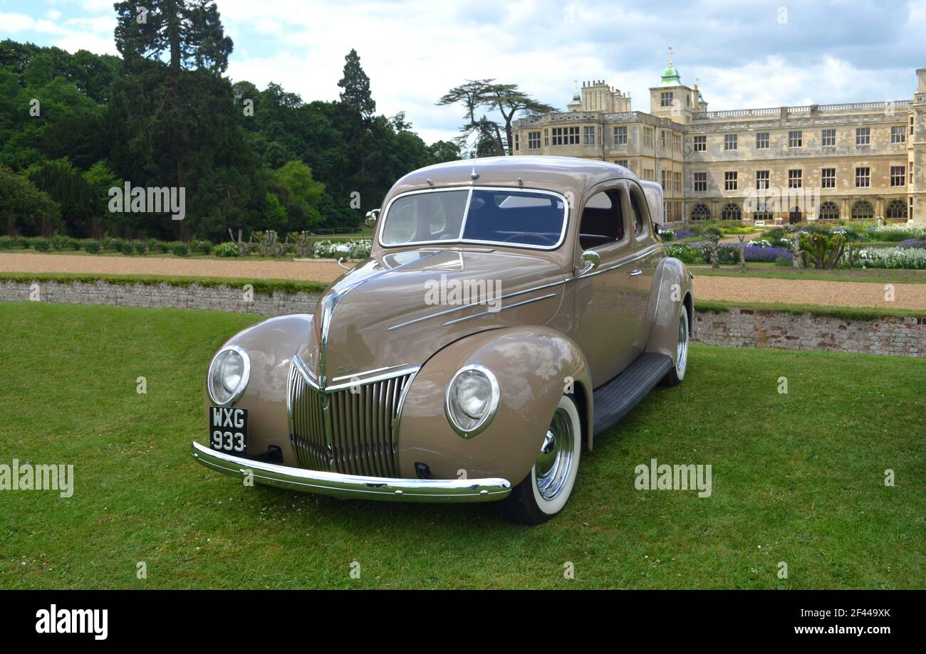 Vintage 1939 Ford 91A Deluxe parcheggiato su prato di fronte a casa signorile. Foto Stock