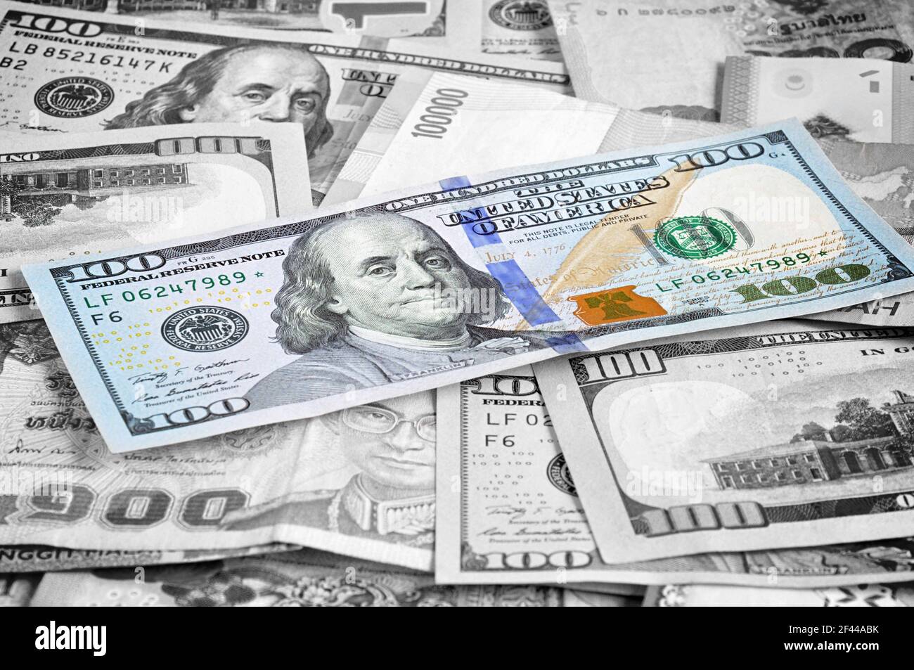 Denaro in più valute con un conto di 100 USD in cima Foto Stock